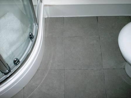 Grout Colour restored on a Ceramic Tiled Bathroom Floor by the Tile Doctor - Before Picture