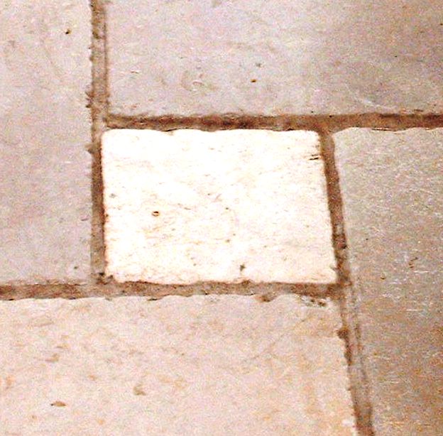 Mixed size marble floor tile with badly discoloured Ivory grout